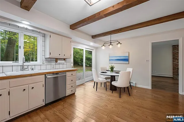 a kitchen with a dining table chairs wooden floor and white appliances
