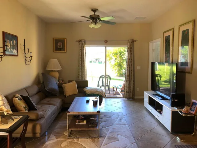 a living room with furniture a window and a flat screen tv