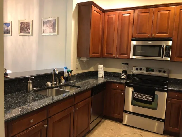 a kitchen with granite countertop a stove microwave and sink