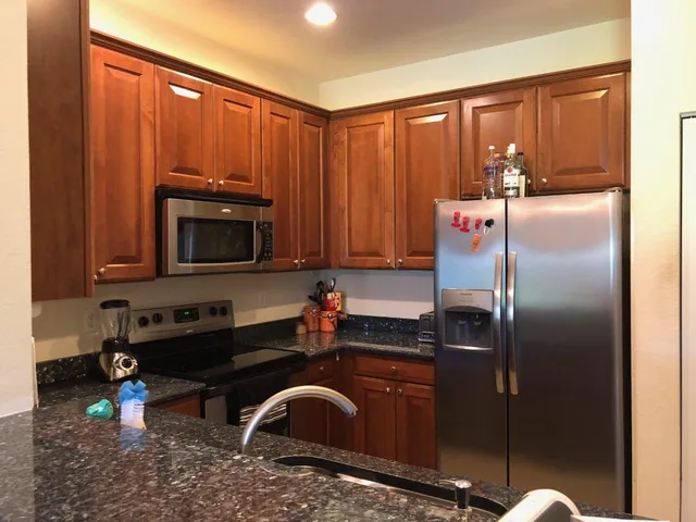 a kitchen with a refrigerator sink and cabinets