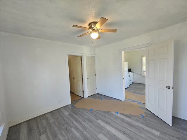 a view of a livingroom with a chandelier fan and wooden floor