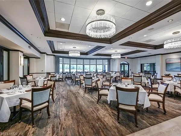 a outdoor space with lots of tables a large window and furniture