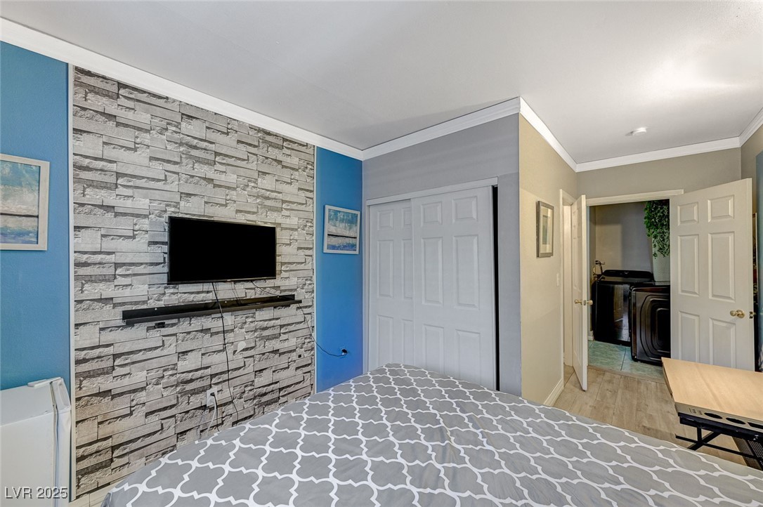 3266 Mountain Spring Road Las Vegas, NV 89146 - Photo 38 of 49 Unfurnished bedroom with wood finished floors, a closet, and crown molding