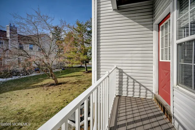 a view of a balcony with wooden floor and fence
