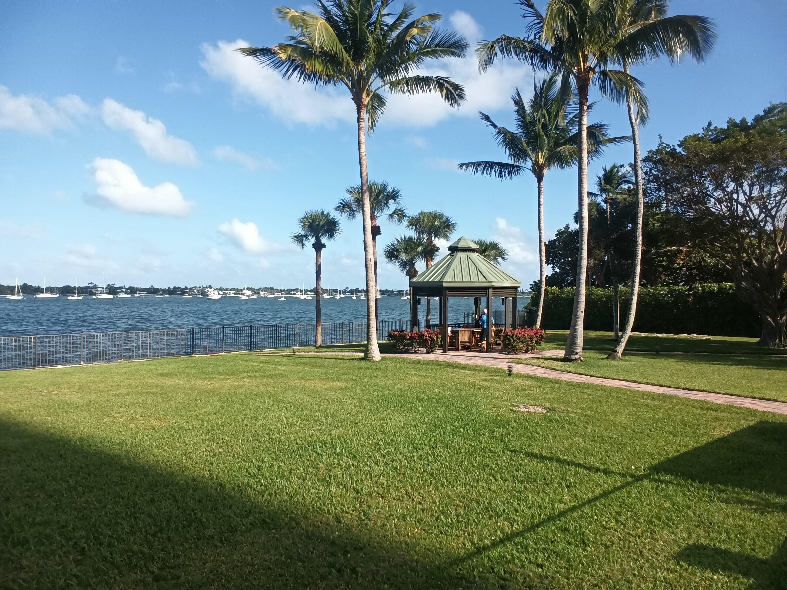 5200 North Flagler Drive, Unit 702 West Palm Beach, FL 33407 - Photo 11 of 36 a view of a swimming pool and a yard
