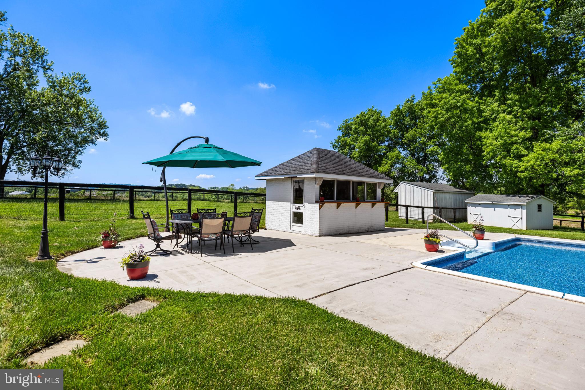 13128 Long Green Pike Baldwin, MD 21013 - Photo 114 of 124 a view of a patio with a table and chairs under an umbrella