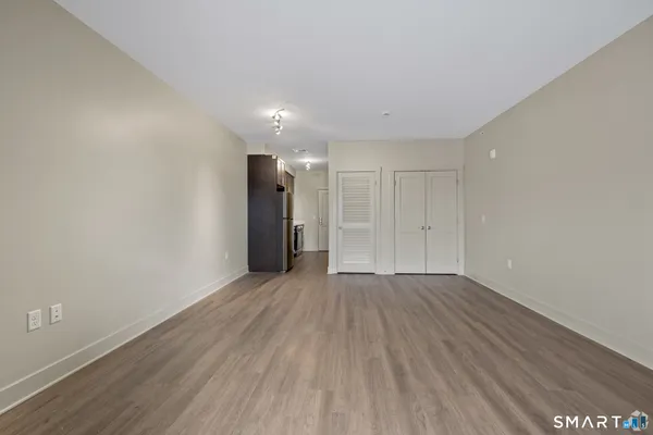 a view of an empty room with wooden floor