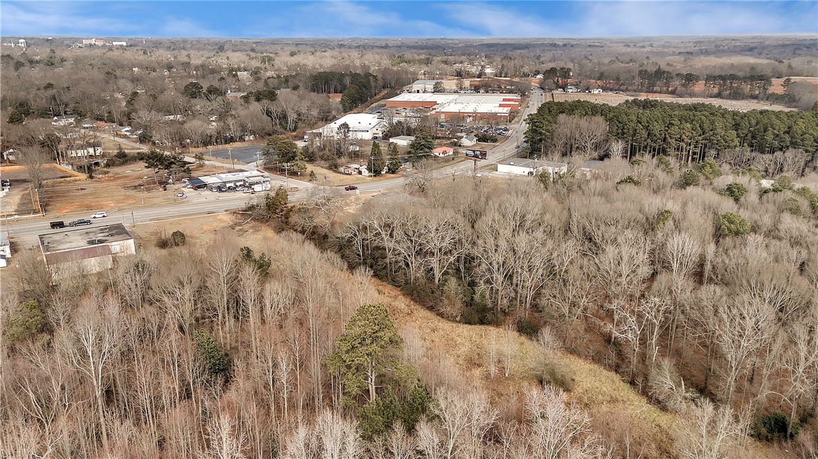 Tr A East Shockley Ferry Road Anderson, SC 29624 - Photo 5 of 10 An aerial perspective reveals a vast wooded expanse bordering a busy highway with commercial properties.