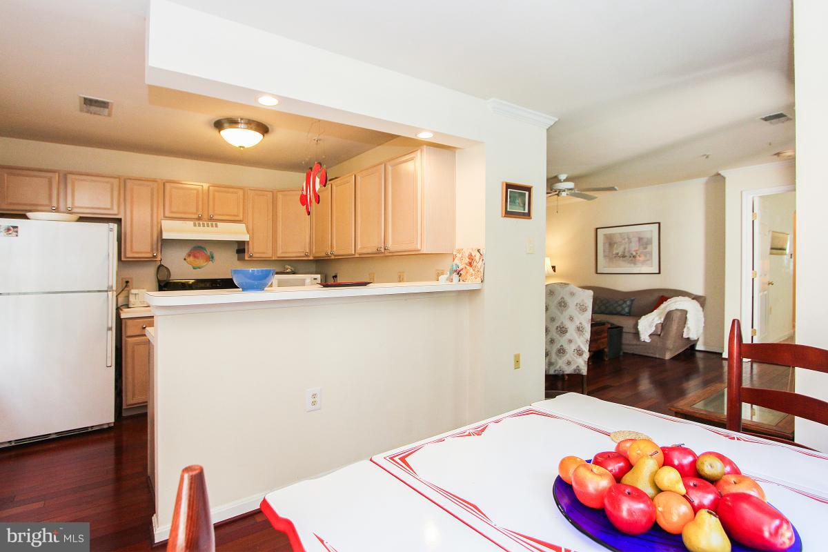 119 Timberbrook Lane, Unit 101 Gaithersburg, MD 20878 - Photo 13 of 29 a kitchen with stainless steel appliances kitchen island granite countertop a refrigerator a sink dishwasher and white cabinets with wooden floor