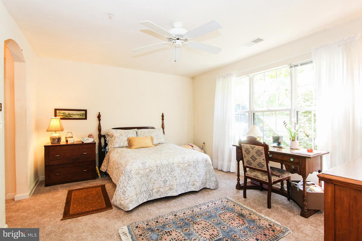 119 Timberbrook Lane, Unit 101 Gaithersburg, MD 20878 - Photo 15 of 29 a bedroom with a bed and a table