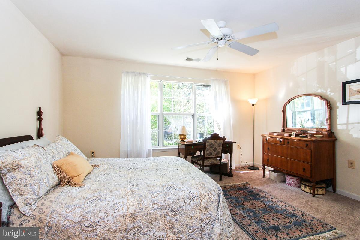 119 Timberbrook Lane, Unit 101 Gaithersburg, MD 20878 - Photo 17 of 29 a bedroom with a bed couch and a large window