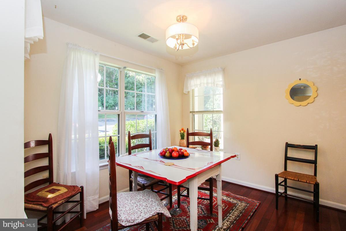 119 Timberbrook Lane, Unit 101 Gaithersburg, MD 20878 - Photo 10 of 29 a view of a dining room with furniture window and wooden floor