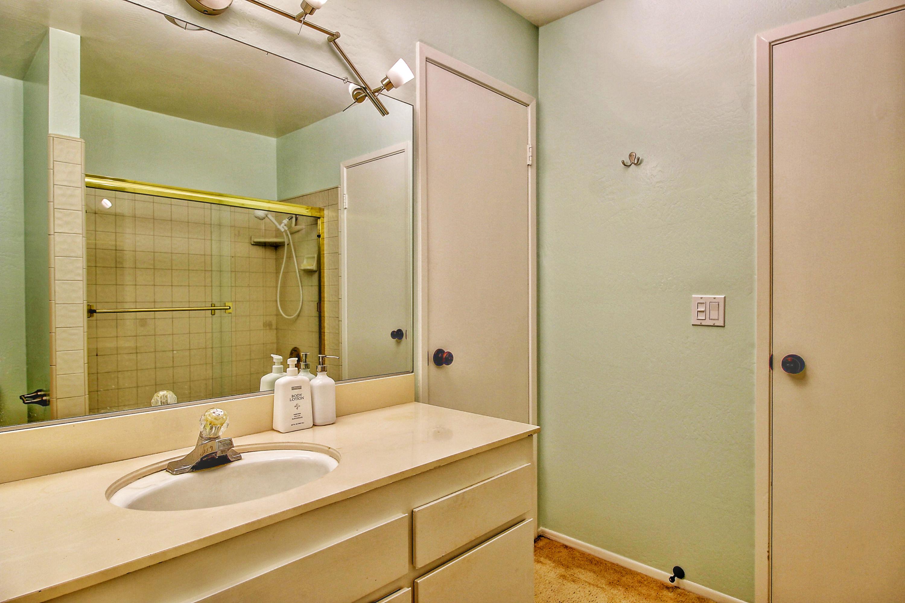 51 North San Marcos Road, Unit B Santa Barbara, CA 93111 - Photo 11 of 24 a bathroom with a granite countertop sink shower and a mirror