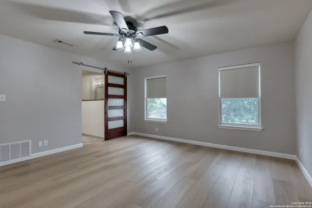 a spacious bathroom with double sink and two mirror