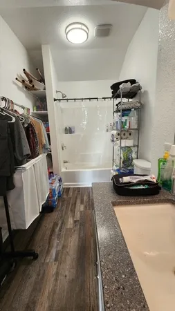 a view of walk in closet with clothes and shoes