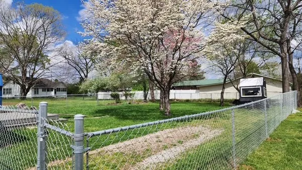 a view of a house with backyard and trees