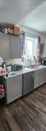a room with granite countertop a sink and a stove top oven