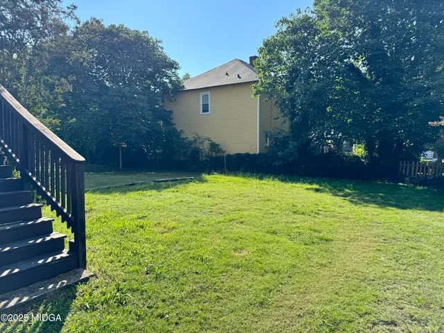 a view of a house with a yard and sitting area