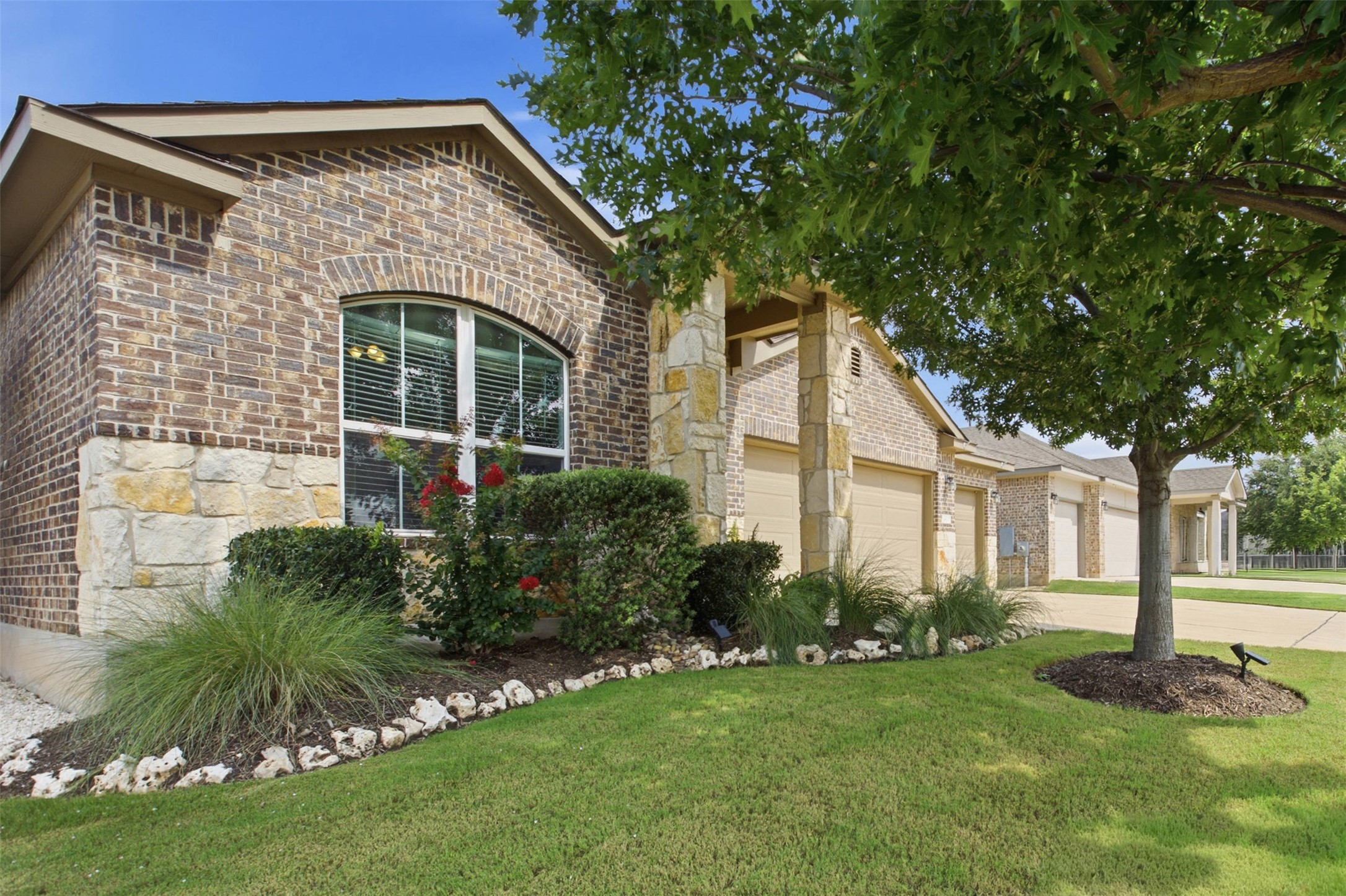 2413 Bridges Ranch Road Georgetown, TX 78628 - Photo 3 of 31 A well-maintained lawn and verdant landscaping complement the brick and stone exterior of this charming residence.