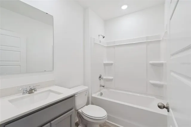 a bathroom with a granite countertop sink toilet a mirror and shower