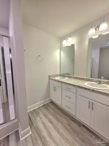 a spacious bathroom with a granite countertop sink and a mirror