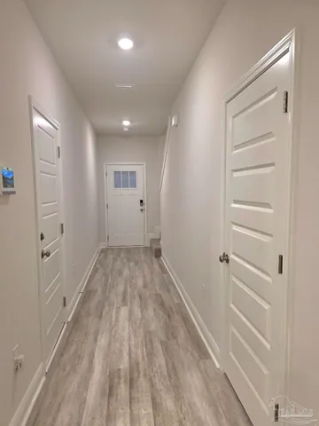 a view of a hallway with wooden floor