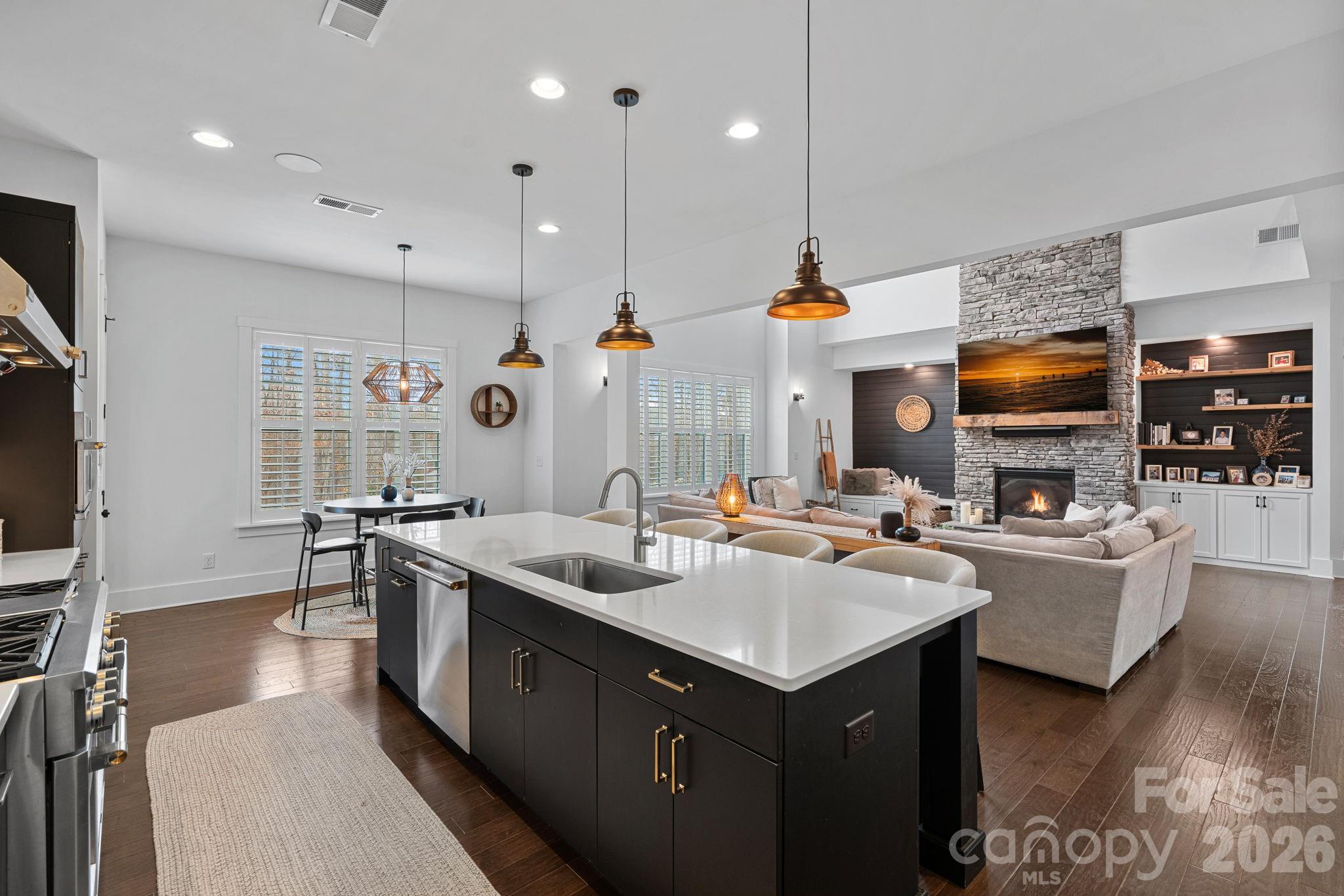 18401 Doves Crest Road Cornelius, NC 28031 - Photo 16 of 39 a kitchen with stainless steel appliances granite countertop a sink a stove and a wooden floors