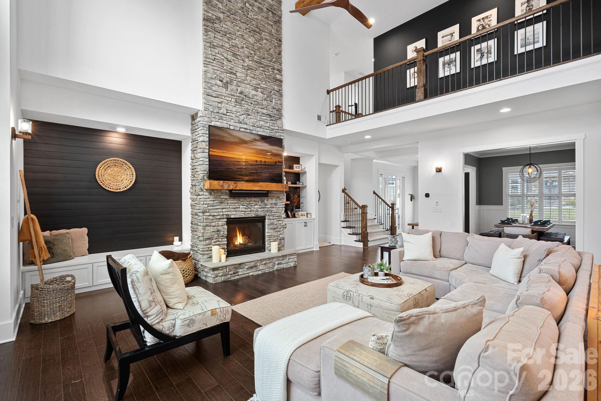 18401 Doves Crest Road Cornelius, NC 28031 - Photo 10 of 39 a living room with furniture a fireplace and a flat screen tv