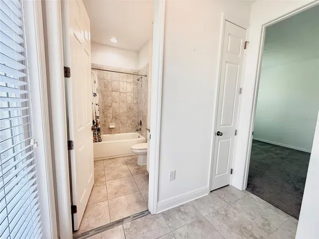 a bathroom with a granite countertop sink a toilet a mirror a bathtub and shower