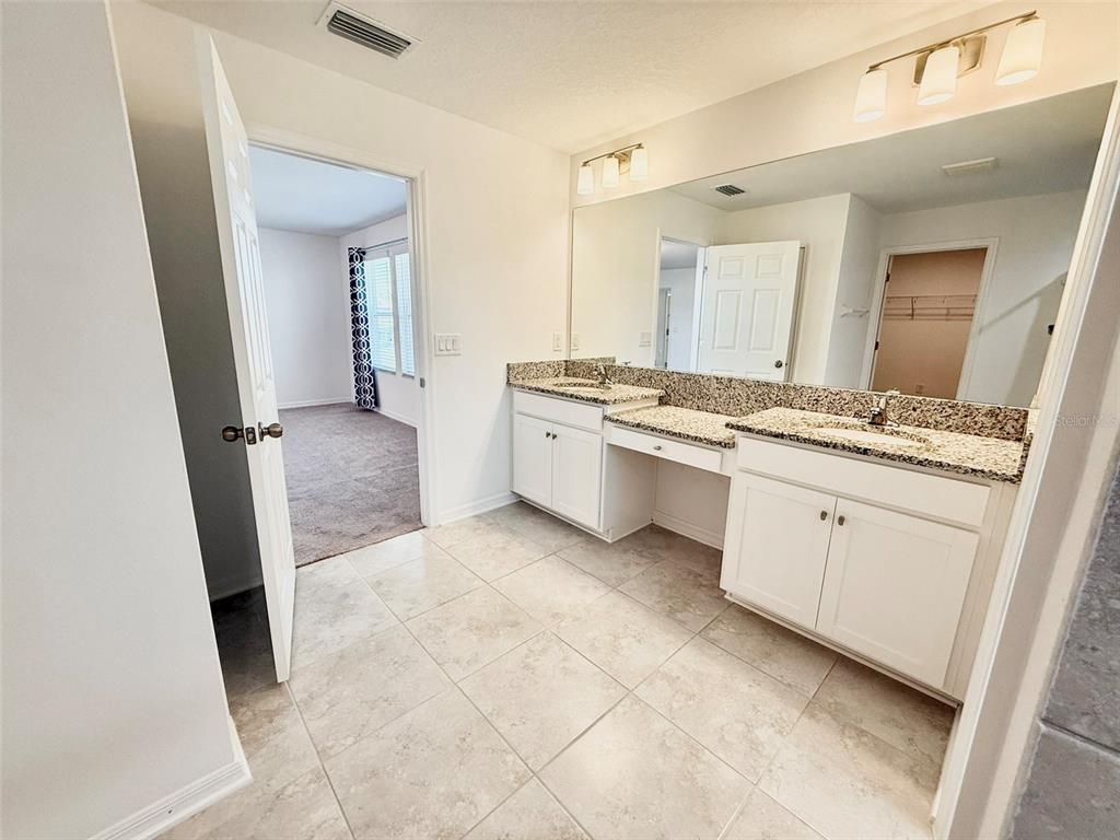 12189 Nouveau Avenue Spring Hill, FL 34610 - Photo 28 of 50 a large white bathroom with a granite countertop sink and a mirror