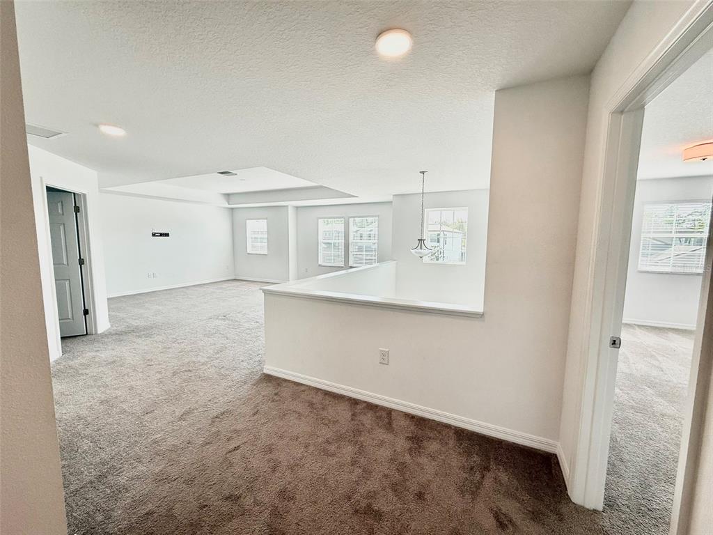 12189 Nouveau Avenue Spring Hill, FL 34610 - Photo 38 of 50 a view of an empty room with wooden floor and a window
