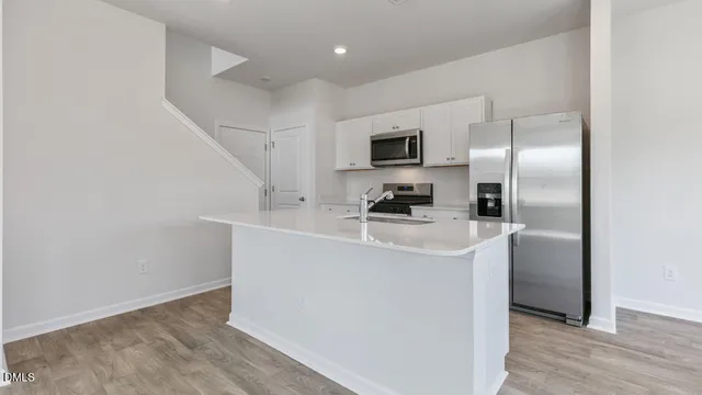 a kitchen with kitchen island a sink stainless steel appliances and refrigerator