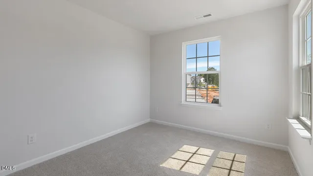 an empty room with windows and cabinet