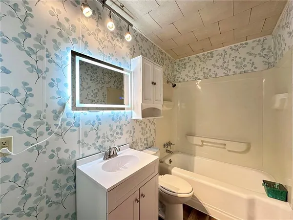 a bathroom with a sink toilet vanity and shower