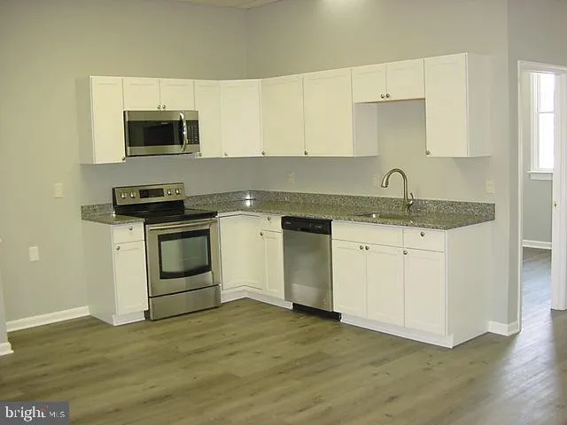 a kitchen with a sink stove and microwave