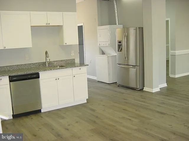 a kitchen with a sink a refrigerator and cabinets