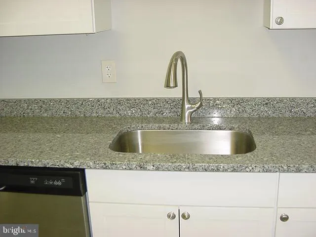 a kitchen with granite countertop a sink and a stove