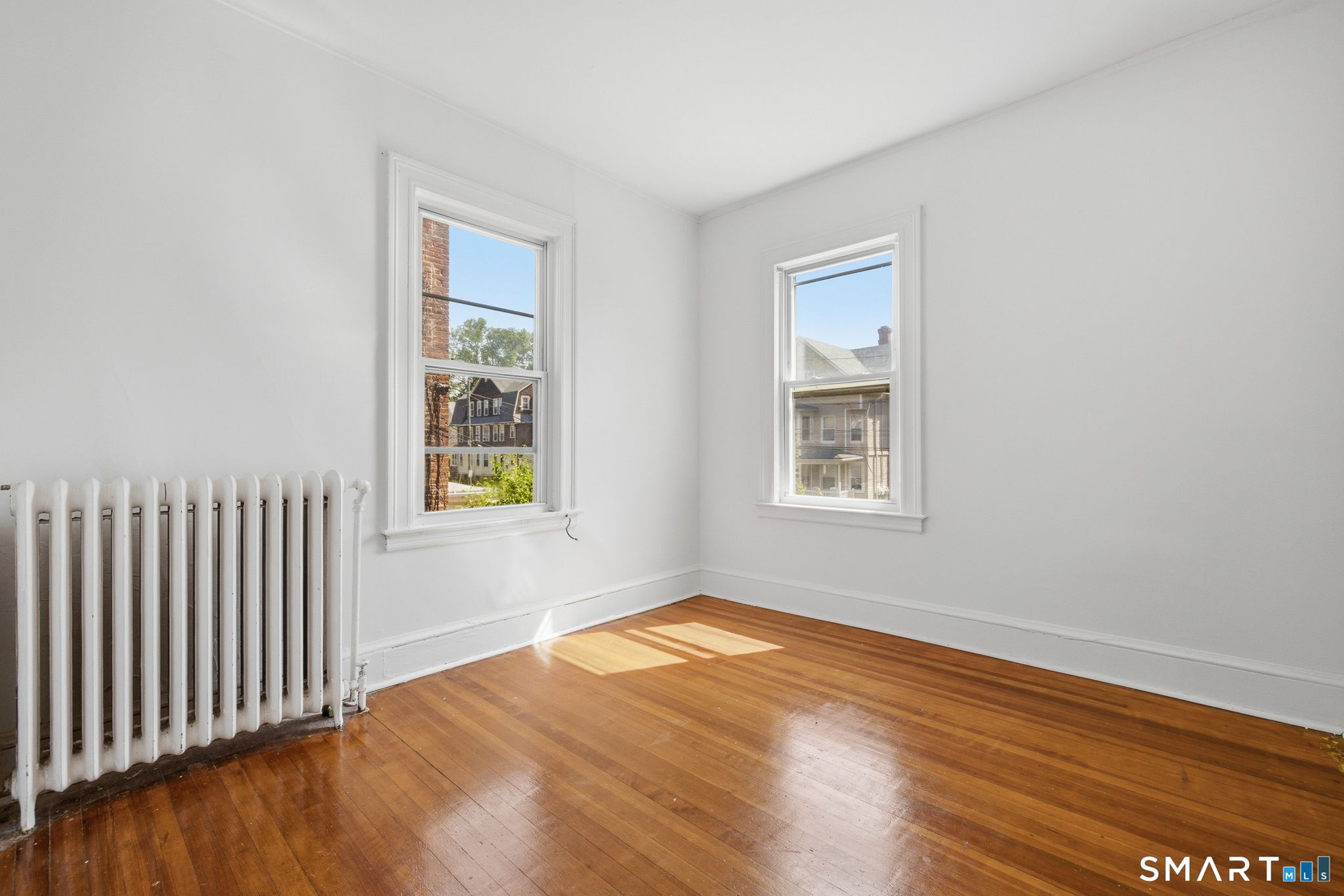 115 Baltimore Street, Unit 2 Hartford, CT 06112 - Photo 13 of 14 a view of an empty room with wooden floor and a window