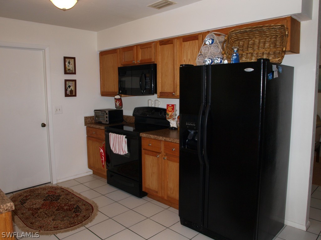 13034 First Street Fort Myers, FL 33905 - Photo 4 of 18 a kitchen with a refrigerator and a stove