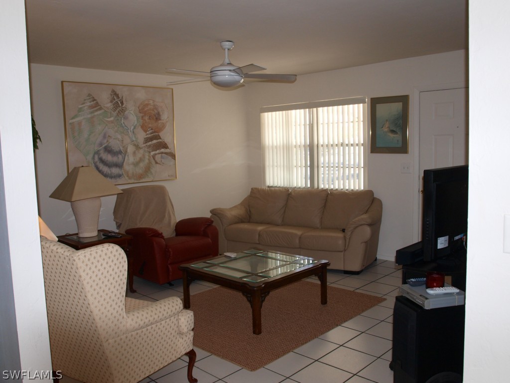 13034 First Street Fort Myers, FL 33905 - Photo 9 of 18 a living room with furniture a large window and a flat screen tv