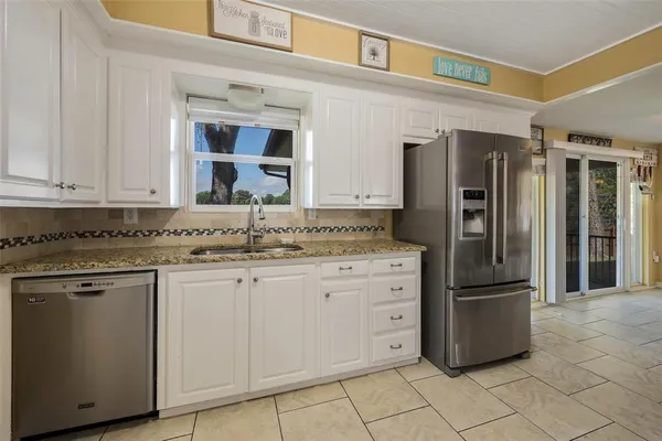 a kitchen with stainless steel appliances granite countertop a refrigerator and a sink