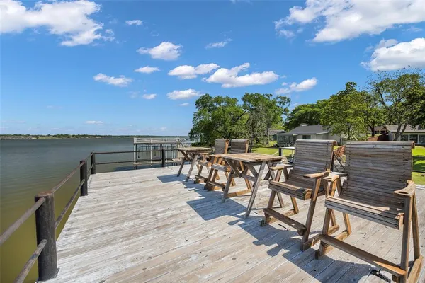 a view of a chairs and table on the wooden deck with a patio