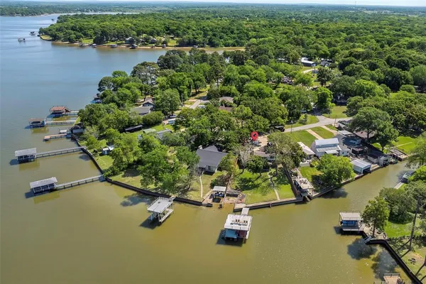 an aerial view of a house with a yard and lake view