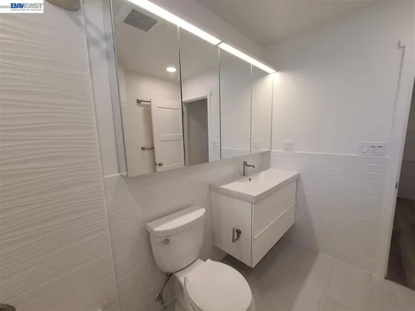 a bathroom with a sink a toilet and mirror