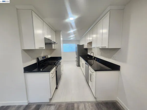 a kitchen with stainless steel appliances granite countertop a sink stove and cabinets