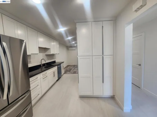 a large white kitchen with stainless steel appliances refrigerator sink and cabinets