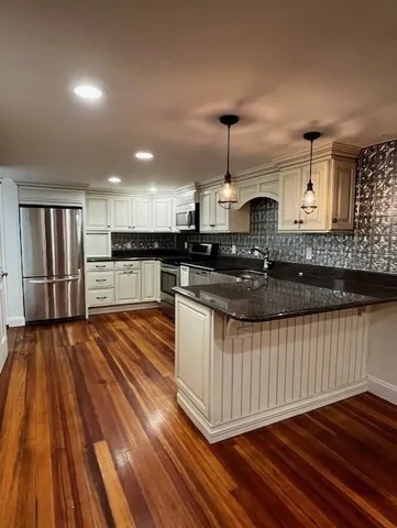 a kitchen with stainless steel appliances granite countertop a sink stove and wooden floor