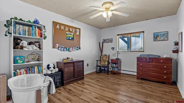 a view of a livingroom with wooden floor and a ceiling fan