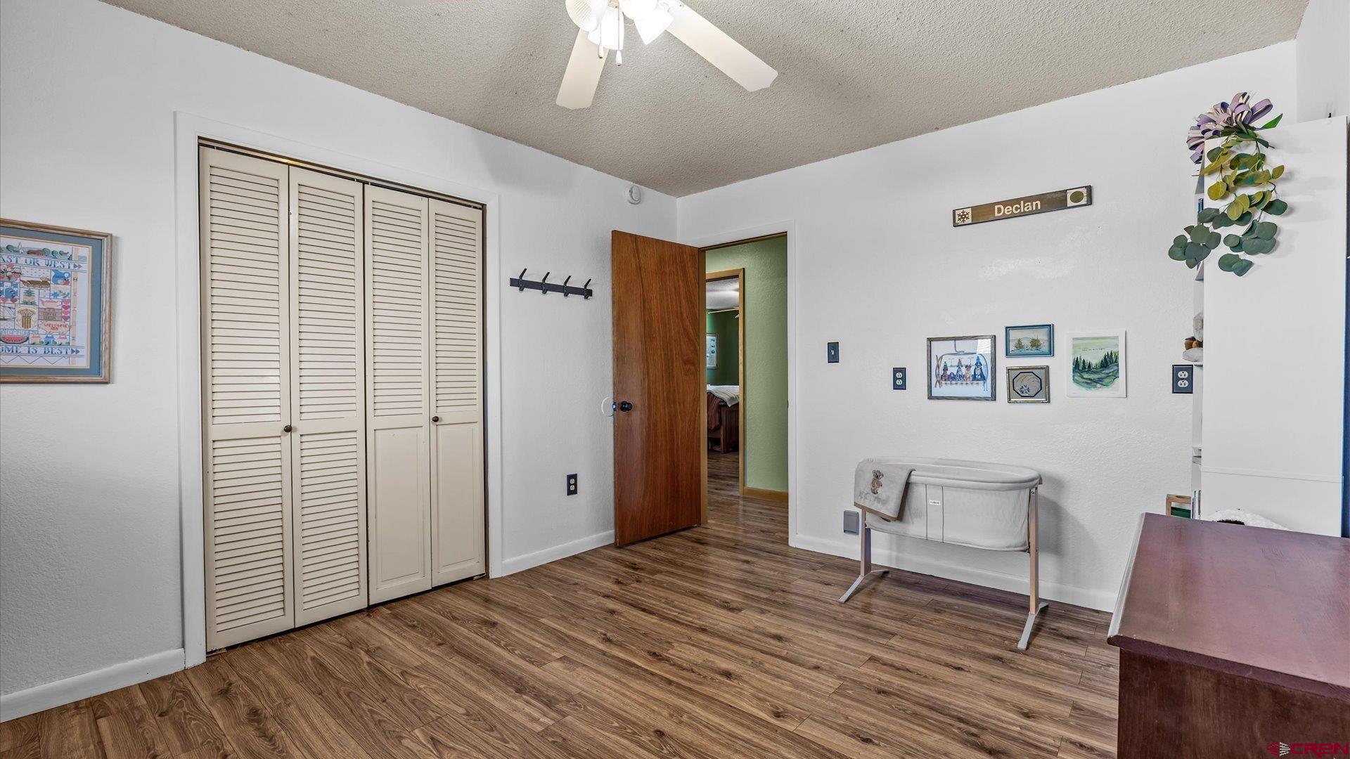 16205 6700th Road Montrose, CO 81401 - Photo 6 of 34 a view of a livingroom with wooden floor and a ceiling fan