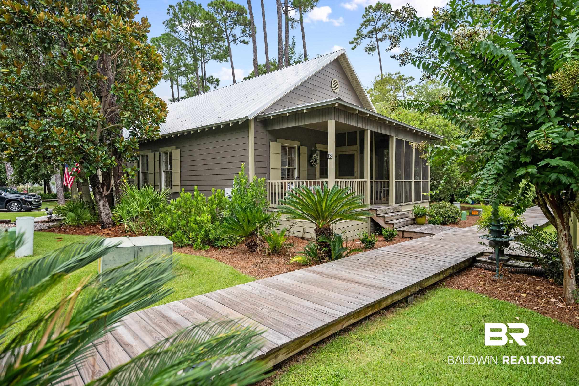 Rear view of property featuring a lawn and a sunroom